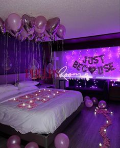 balloons and streamers fill the air above a bed in a room with purple lighting