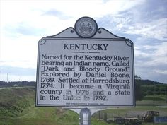 a sign that is in front of some grass and dirt on the side of a road