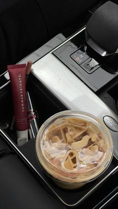 a glass container filled with liquid sitting on top of a table next to a laptop