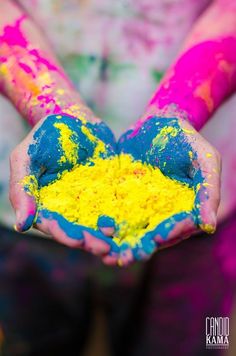 a child's hands are covered in colored powder