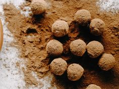 several balls of sand on the ground next to a wooden spoon