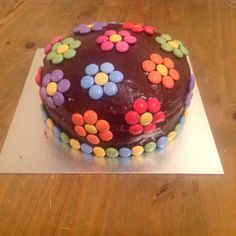 a chocolate cake with colorful flowers on it