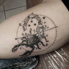 a black and white photo of a scorpion tattoo on the left arm with stars around it