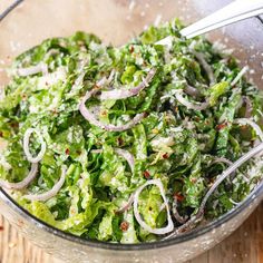 a glass bowl filled with salad and onions