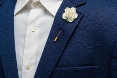 a man wearing a blue jacket with a white rose on it's lapel