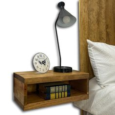 a nightstand with a clock and books on it next to a night stand that is made out of wood