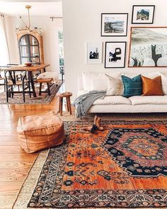 a living room filled with lots of furniture and pictures on the wall above it's couch