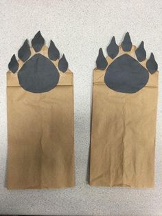 two brown paper bags with black paws on them