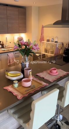 a kitchen counter with plates, bowls and flowers on it in front of the sink