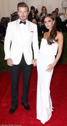 a man in a tuxedo and a woman in a white dress holding hands