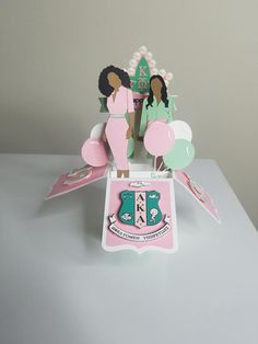 two women in pink dresses are standing on top of a table with paper cutouts