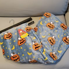 an orange and blue halloween themed blanket with pumpkins on it next to a pen