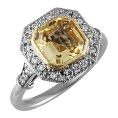 a fancy yellow diamond ring set in 18k white gold with diamonds around the band