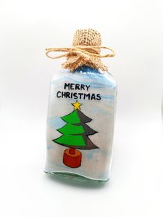 a glass bottle with a christmas tree on it