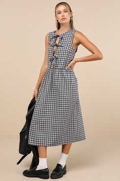 With an easy-wearing fit and adorable details, the Motel Prelith Black Gingham Tie-Front Midi Dress is ready to impress! Crisp woven cotton boasts a playful gingham print throughout as it shapes a sleeveless bodice with a crew neckline and a trio of functional ties at the front. Relaxed silhouette boasts a gathered waist, atop a wide-cut, shift-style skirt that ends at a midi hem. Fit: This garment fits true to size. Length: Mid-calf length. Size medium measures 47.5" from shoulder to hem. Bust: Great for any cup size. Waist: Loosely Fitted. Hip: Not Fitted - fuller skirt allows room for hips. Undergarments: May be worn with petals, or no bra. Fabric: Fabric has no stretch. Unlined. 100% Cotton. Hand Wash In Cold Water. Wash Separately. Do Not Soak. Do Not Bleach. Do Not Tumble Dry. Dry Fl Black Gingham, Cotton Midi Dress, Style Skirt, Gingham Print, Woven Cotton, Dress 100, Large Size Dresses, Full Skirt, Skirt Fashion