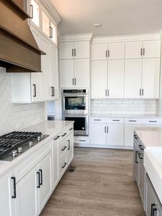 a kitchen with white cabinets and an oven