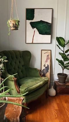 a living room with a green couch and potted plants on the wall next to it