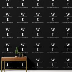 a black wall with white letters on it and a table in front of the wall