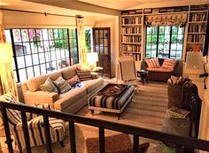 a living room filled with furniture and lots of bookshelves on top of it