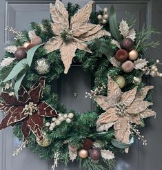 a christmas wreath with poinsettis and greenery hangs on the front door