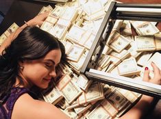 a woman sitting on the floor surrounded by stacks of money