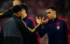 two soccer players are talking to each other on the sidelines with their hands together