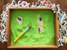 a wooden box with paper cut outs and a paintbrush in it