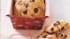 two chocolate chip cookies in a box next to a red string