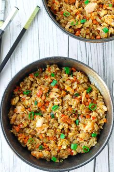 garlic salmon fried rice in a skillet with green onions and carrots on the side