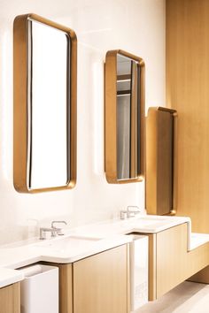 a bathroom with two sinks and mirrors on the wall