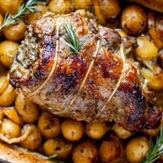 meat and potatoes in a roasting pan with rosemary garnish on top, ready to be eaten