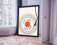 there is a poster on the floor in front of a window with an orange record