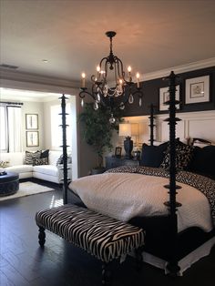 a bedroom with a zebra print bed and chandelier