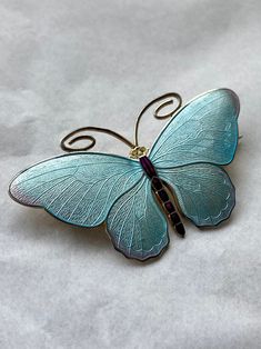 A wonderful sterling silver and enamel butterfly brooch by Marius Hammer of Bergen Norway. Beautiful stunning enamel colours, a lovely pale iridescent blue, with tints of pale amethyst at the wingtips. The body is a deep purple. Good condition, gilding to reverse. Measures 2 3/8 across. Thanks for looking. Shipping worldwide, tracked and signed. Royal Mail I international tracked and signed Covers items up to £250.00 PLEASE BE AWARE, IF CHOOSING ROYAL MAIL INTERNATIONAL TRACKED AND SIGNED YOUR O Elegant Butterfly Shape Metal Jewelry, Delicate Butterfly-shaped Sterling Silver Jewelry, Handmade Butterfly-shaped Metal Jewelry, Elegant Silver Butterfly Brooch, Elegant Blue Butterfly Brooches, Victorian Silver Enamel Brooches, Enamel Butterfly, Bergen Norway, Iridescent Blue