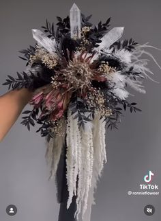 a person holding a bouquet with feathers on it