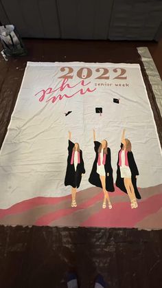 two women in graduation gowns are standing under a banner that reads, 2012 graduating