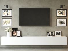 an entertainment center in a living room with pictures on the wall