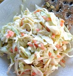 a white plate topped with pasta and coleslaw