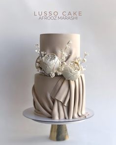 a three tiered cake with white flowers on top