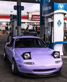 a purple car parked in front of a gas station