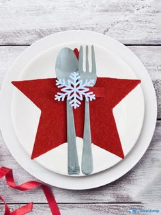 a white plate topped with a red and white star cut out of felt next to silverware