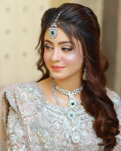 a woman with long hair wearing a tiara and jewelry