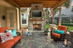 an outdoor living area with couches, chairs and a fire place in the center