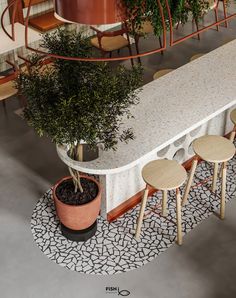 a table with four stools and a potted plant on the floor next to it