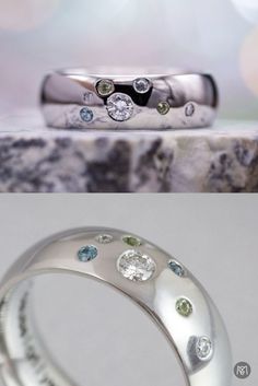 two wedding rings with different colored stones on them and one has a diamond in the middle