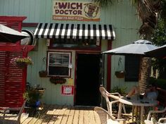 the outside of a restaurant with tables and umbrellas