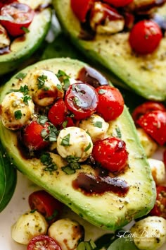 an avocado with tomatoes and other vegetables on it