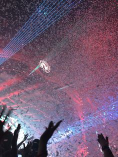 people are standing in front of a stage with lights and confetti