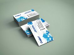 two business cards stacked on top of each other in front of a gray background with blue and white designs