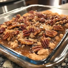 a close up of a tray of food with pecans in it on a table